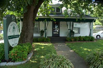The Nurture Nook Day Spa, a white cottage with dark green trim on North Walnut Street